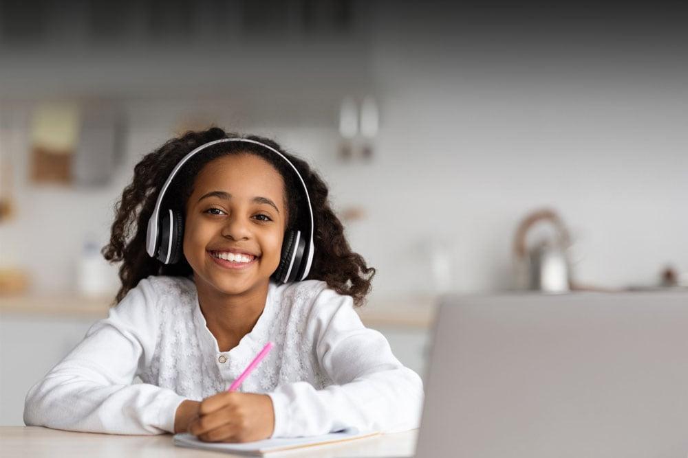 Connections Academy Student with headphones on and working on homework